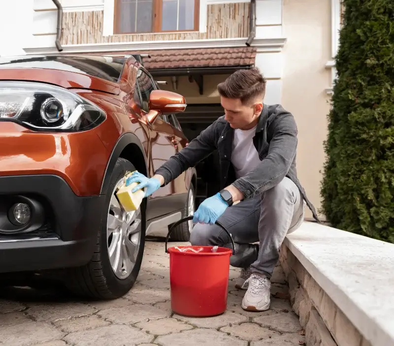 Lavage auto à domicile Castelnau-Pégayrols : professionnel intervenant sur un véhicule